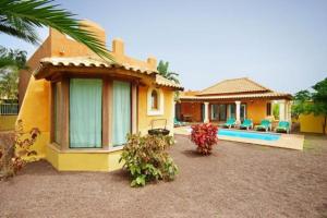 una casa con piscina frente a ella en Villas Brisas del Mar, en Corralejo