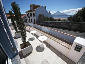 a view from the roof of a building with tables and trees at Manta Ray Lodge in Horta