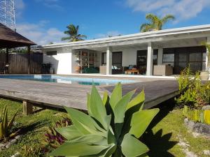 a villa with a swimming pool and a house at Sunset Quay in Rarotonga