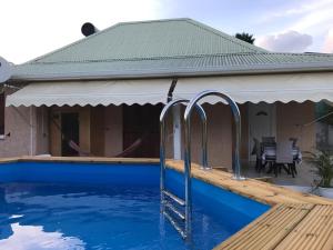 a house with a swimming pool with a roof at Villa Kapiopa in Sainte-Anne