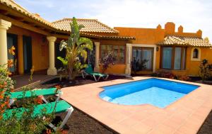 コラレホにあるVillas Brisas del Marの庭にスイミングプールがある家