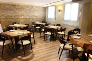 a dining room with tables and chairs and a brick wall at El Cierzo de Javalambre in Arcos de las Salinas