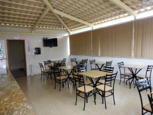 a room with tables and chairs and a flat screen tv at Brasil Center Hotel in João Monlevade