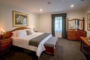 a bedroom with a large bed and a mirror at Brockenchack Vineyard Bed & Breakfast in Mount McKenzie