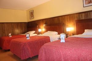 a hotel room with two beds with stuffed animals on them at Hotel El Tumi 2 in Huaraz