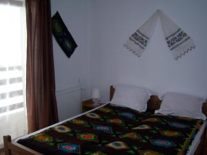 1 dormitorio con cama con edredón en La Curtea Porumbaceana, en Porumbacu de Sus