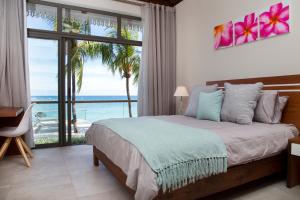 a bedroom with a bed with a view of the ocean at Les 2 canons in Flic-en-Flac