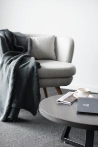 a living room with a chair and a coffee table at Tyrian Serviced Apartments Fitzroy in Melbourne