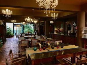a restaurant with wooden tables and chairs and chandeliers at Golden Lotus Bangalore Boutique Suites in Bangalore