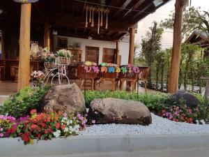 a garden with rocks and flowers in front of a house at Good Home@Udon Thani Resort in Ban Nong Khun