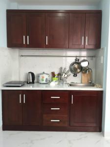 a kitchen with wooden cabinets and a sink at Greenfield Nha Trang Apartments for rent in Nha Trang +31 photos