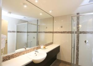 a bathroom with a sink, mirror, and bathtub at Best Western Plus Hovell Tree Inn in Albury