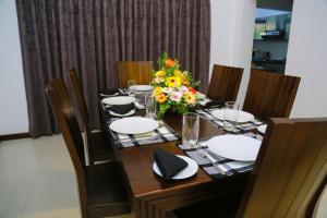Miyura Holiday Bungalow في كاندي: طاولة عليها صحون و إناء من الزهور