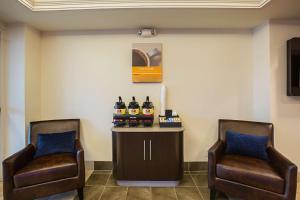 Motel 6-Grand Island, NE في Doniphan: كرسيان في غرفة انتظار مع زجاجات من الكحول