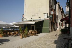 a street with tables and chairs and a building at Apartment Santa Croce Free Parking in Rovinj