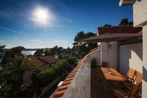 マリ・ロシニにあるApartments Tashaの家の上に椅子とパラソル付きのバルコニー