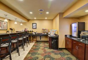 a restaurant with a bar with stools and a counter at Cobblestone Hotel & Suites - Punxsutawney in Punxsutawney