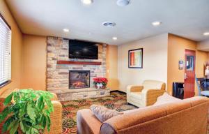 a living room with a couch and a fireplace at Cobblestone Hotel & Suites - Punxsutawney in Punxsutawney