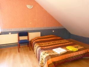 a bedroom with a bed and a chair in a attic at Viva Pirita Hostel in Tallinn