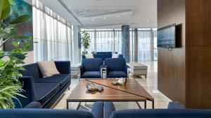 a living room with blue couches and a table at Gaia Sun N Blue Hotel in Ayia Napa
