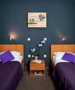 um quarto com duas camas e uma mesa com flores em Hotel Fala em Zagreb