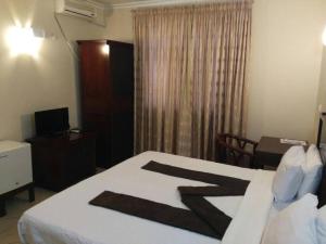 um quarto com uma cama, uma secretária e uma janela em Pensao Marhaba Residencial em Maputo