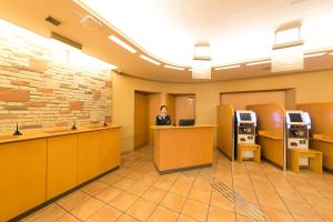 a man is standing at a counter in a lobby at R&B Hotel Umeda East in Osaka