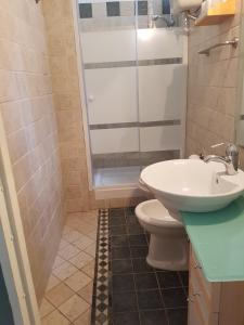 a bathroom with a sink and a toilet and a shower at Appartamento Acquamarina in Trapani
