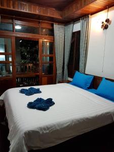 a bedroom with a bed with blue towels on it at Good Home@Udon Thani Resort in Ban Nong Khun