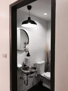 a bathroom with a sink and a toilet and a mirror at Stay in Style at Nimman R208 in Chiang Mai