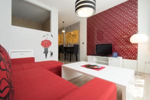 - un salon avec un canapé rouge et une table dans l'établissement Apartment Mango, à Sarajevo