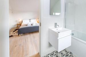 - une chambre avec un lit, un lavabo et un miroir dans l'établissement Laurel Studio, à Aldeburgh