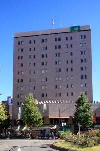 a large building with a street sign on top of it at R&B Hotel Otsuka Eki Kitaguchi in Tokyo