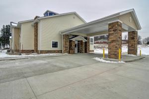 un bâtiment avec un garage et une allée. dans l'établissement Cobblestone Hotel & Suites - Punxsutawney, à Punxsutawney