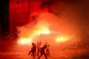 un grupo de personas de pie frente a un fuego en Apartaments Can Gibert, en Castelló d'Empúries