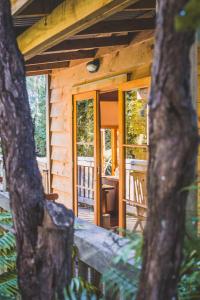 an outside view of a cabin with a table and chairs at Hush Boutique Accommodation in Coromandel Town