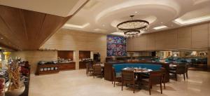 a dining room with tables and chairs in a restaurant at Grand Mercure Vadodara Surya Palace in Vadodara