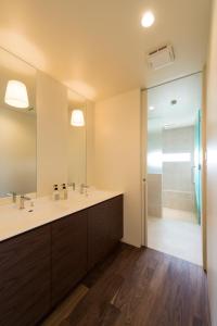 a bathroom with a sink and a large mirror at Guest Villa on the BI-CHI in Sado