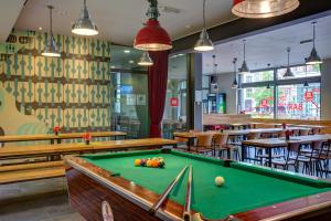 een pooltafel in een restaurant met tafels en stoelen bij MEININGER Hotel Berlin Alexanderplatz in Berlijn