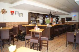 bar w restauracji z drewnianymi stołami i krzesłami w obiekcie Akazienhof Hotel & Brauhaus w Kolonii