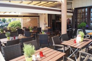 an outdoor patio with wooden tables and chairs at Akazienhof Hotel & Brauhaus in Cologne