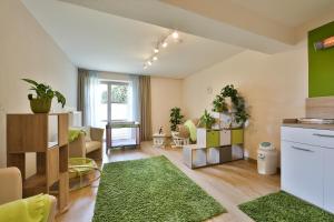 a kitchen and living room with green walls at Sonnenhotel Fürstenbauer in Bodenmais