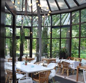 a restaurant with tables and chairs and windows at Droste's Herberg in Tubbergen