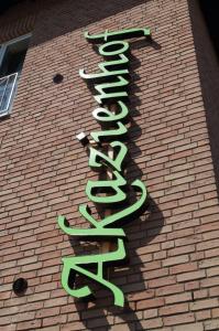 a sign on the side of a brick building at Akazienhof Hotel & Brauhaus in Cologne +5 photos