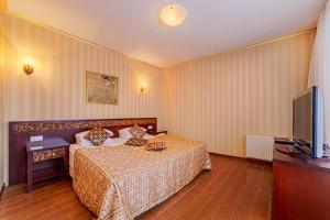 a bedroom with a bed and a flat screen tv at Villa Panama in Odesa