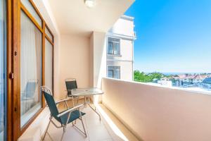 einen Balkon mit einem Tisch und Stühlen sowie einem Fenster in der Unterkunft Villa Panama in Odessa