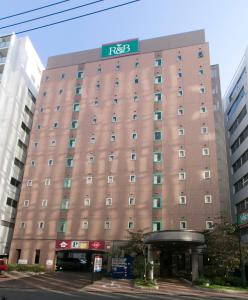 ein großes braunes Gebäude mit einem Schild drauf in der Unterkunft R&B Hotel Nagoya Sakae Higashi in Nagoya