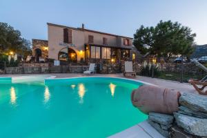 a swimming pool in front of a building at Auberge Lustincone in Patrimonio