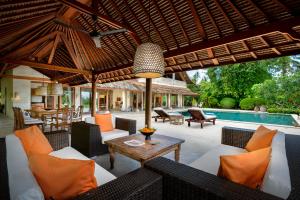 an outdoor patio with chairs and a table and a pool at Villa Bonian Balian in Selemadeg