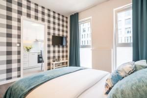 a bedroom with a checkered wall at Apartment Dąbrowskiego by The Railway Station Wroclaw in Wrocław